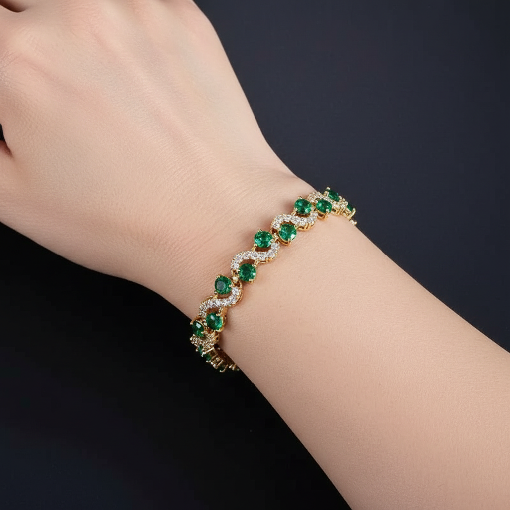 A bracelet featuring brilliant emerald-green cubic zirconia stones in an elegant wave design