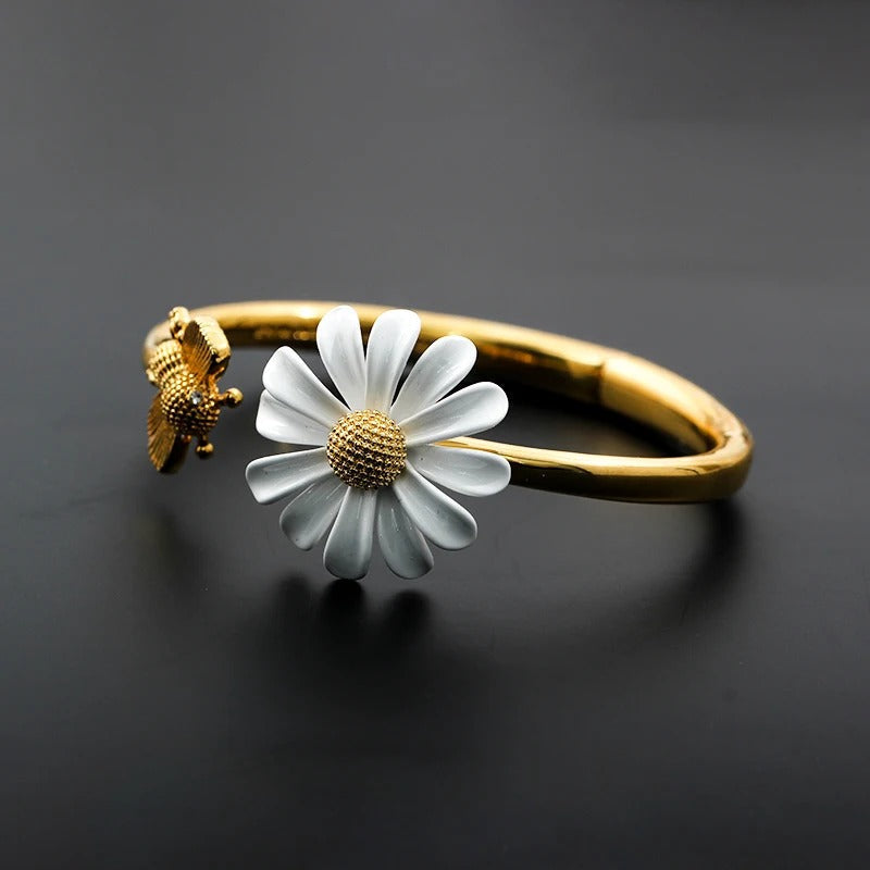 A charming bracelet featuring daisies and bees with floral details