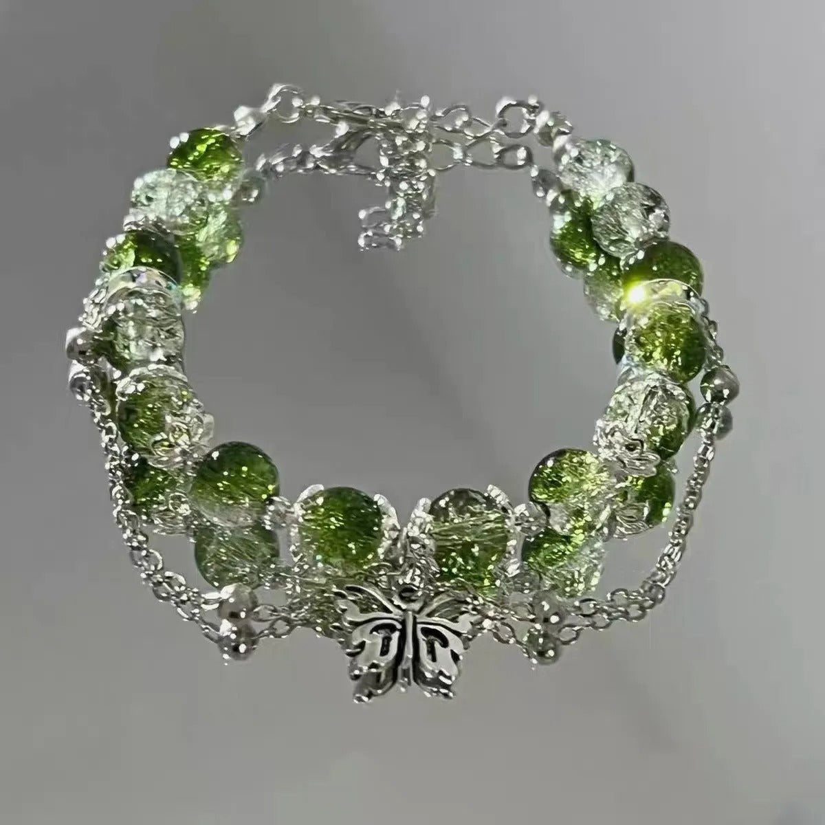 Brilliant beaded bracelet with a green quartz and butterfly charm